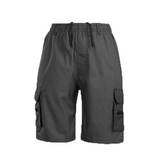 Man draagt MARTI comfortabele cargo shorts in zomerse setting, met zichtbare zijzakken en casual uitstraling – ideaal voor warme dagen.