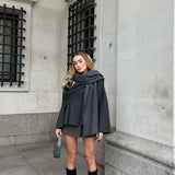 Elegante damesjas met gelaagde look en cape, perfect voor een chique en stijlvolle uitstraling.