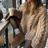 Gezellige kabeltrui voor dames met wijde mouwen, gebreid patroon en ontspannen pasvorm – perfect voor knusse winterdagen.