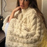 Gezellige kabeltrui voor dames met wijde mouwen, gebreid patroon en ontspannen pasvorm – perfect voor knusse winterdagen.